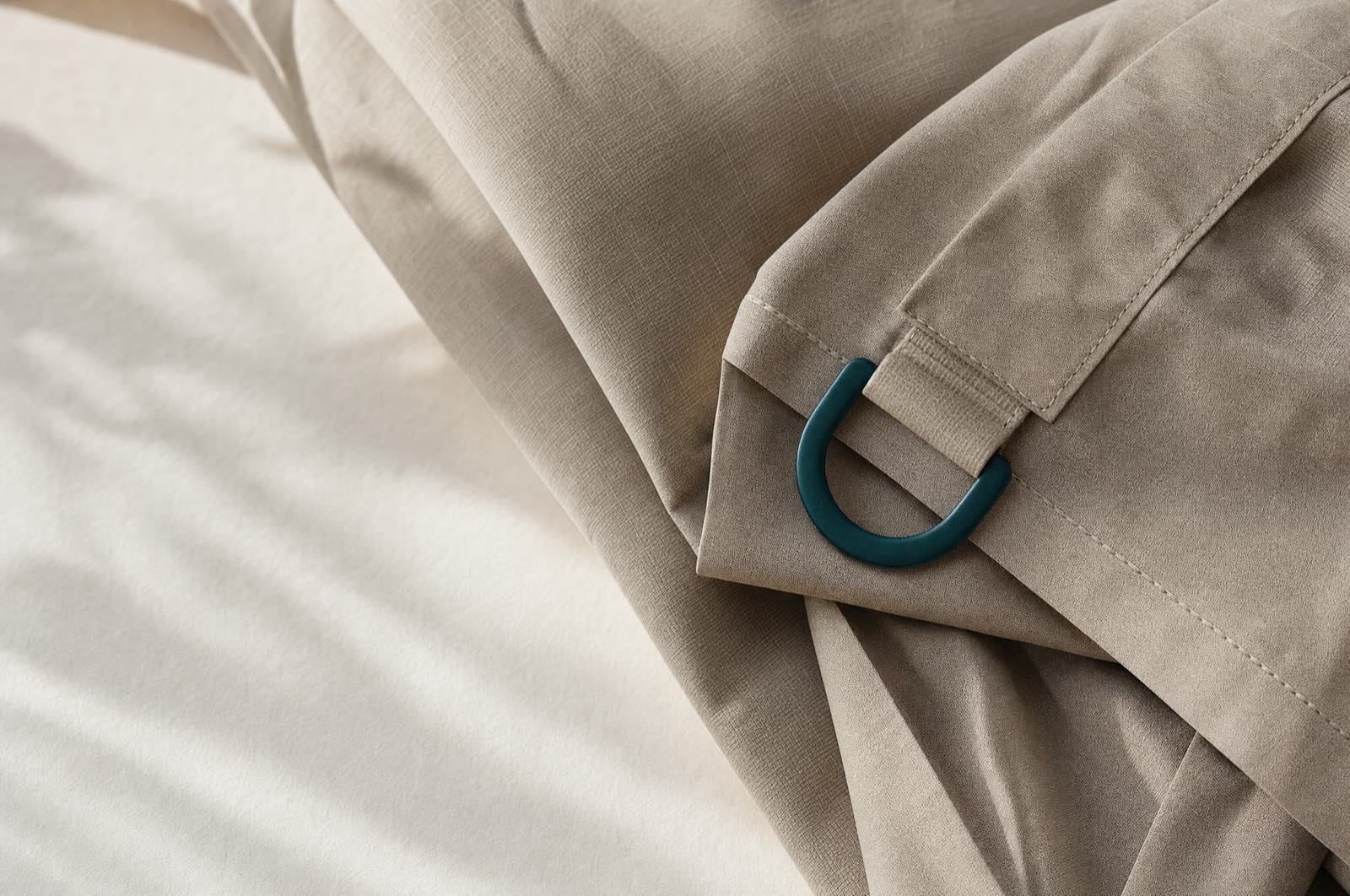 Folded technical outerwear fabric with a matte metal hardware detail