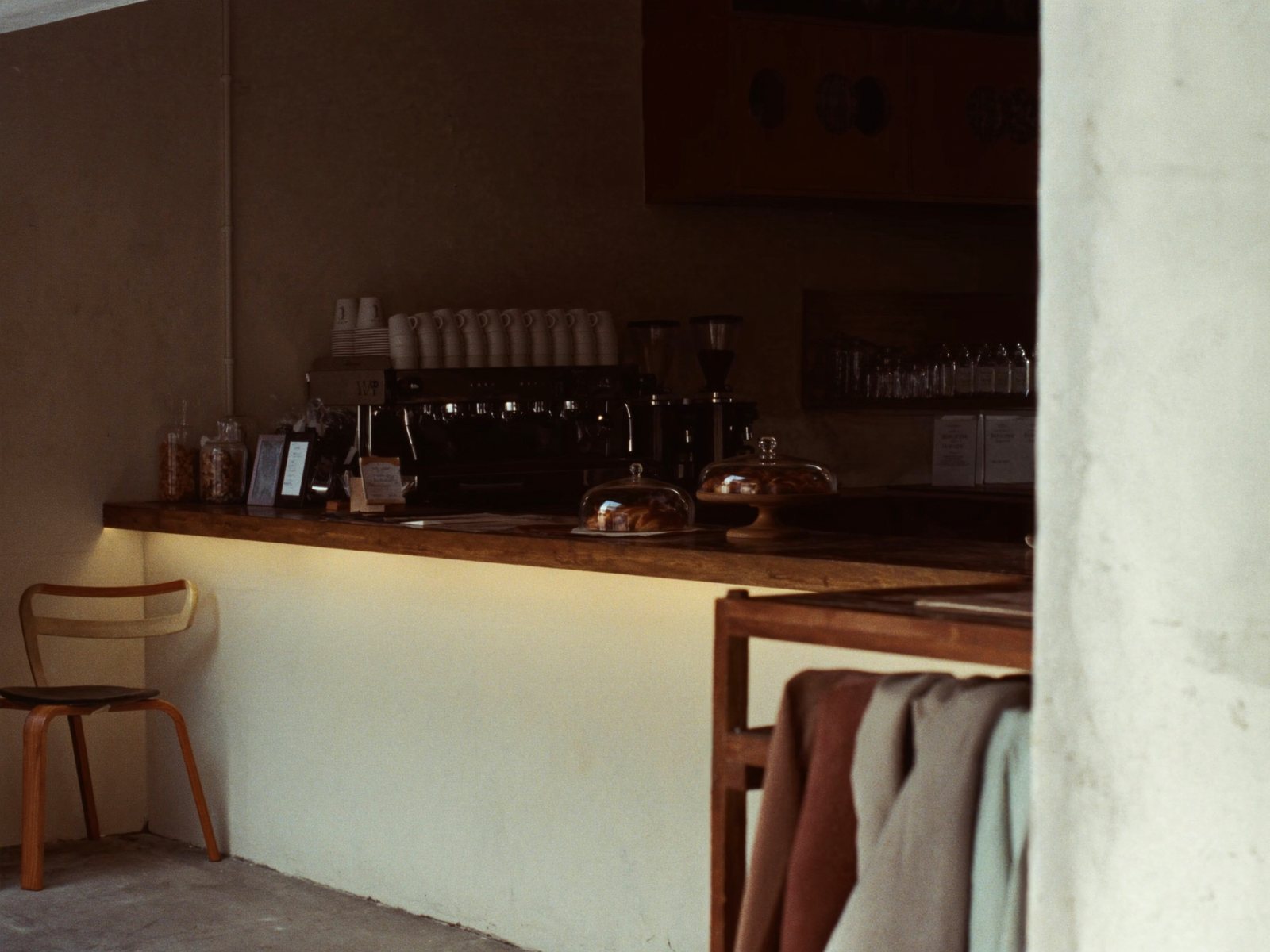 The counter from the doorway, cups stacked on the machine