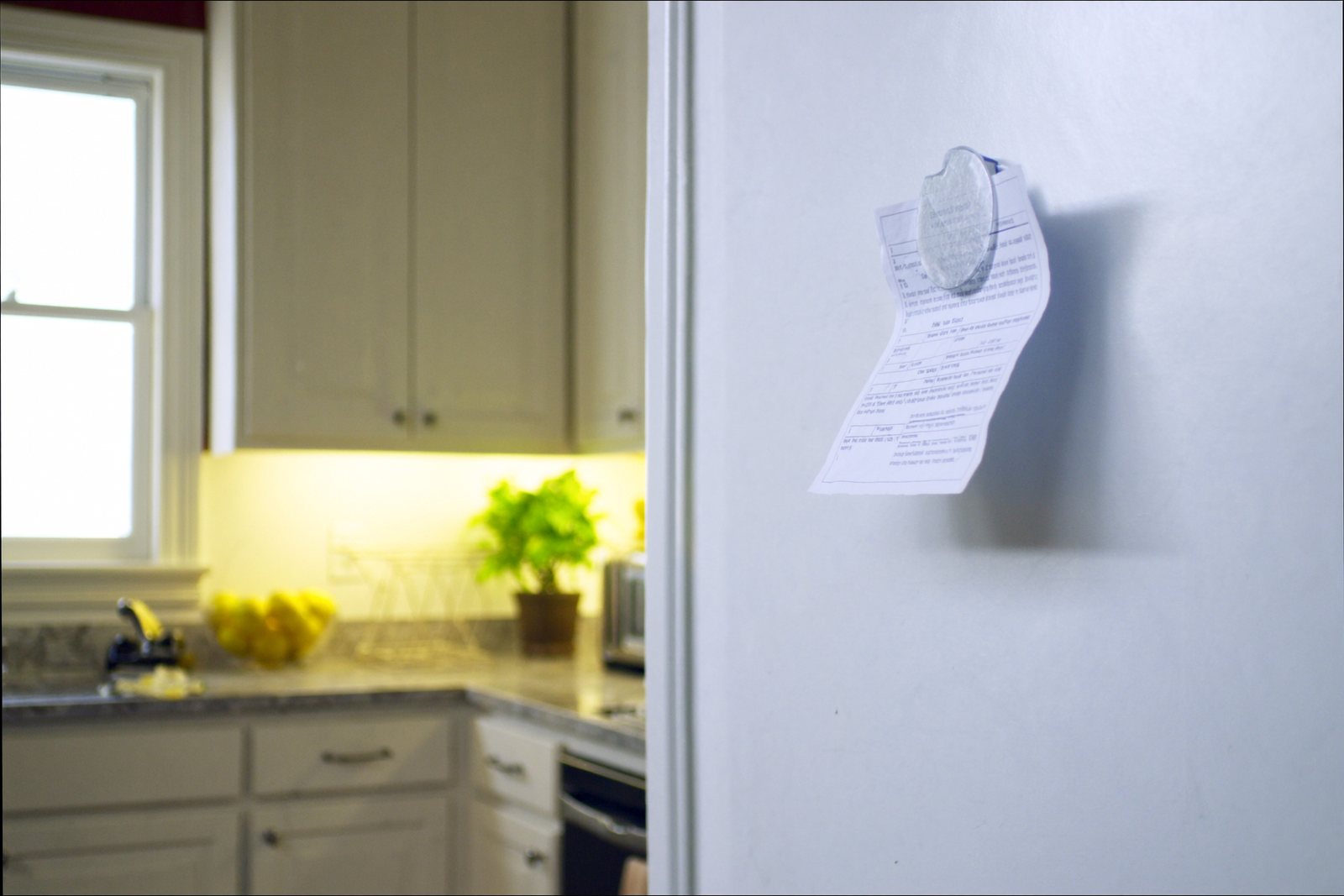 A printed report held to a refrigerator door by a single magnet