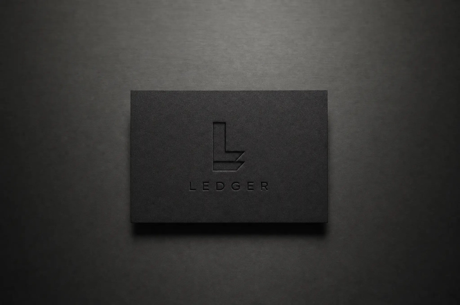 Ledger brand identity — the L monogram debossed on a matte black card